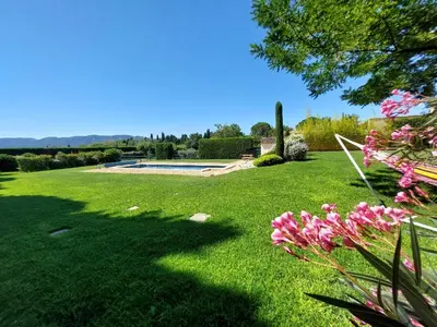 a lawn with pink flowers and a swimming pool at En Provence, Chez Stéphanie et Marcel in Saint-Rémy-de-Provence