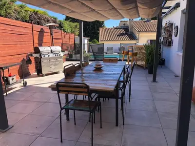 a wooden table and chairs on a patio with a grill at Villa Provence Baraka centre-ville in Salon-de-Provence