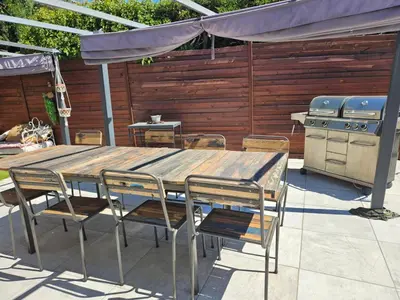 a wooden table and chairs and a grill on a patio at Villa Provence Baraka centre-ville in Salon-de-Provence