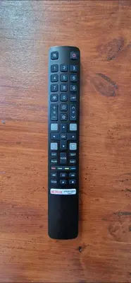 a remote control sitting on top of a wooden table at Cosy House in Carpentras