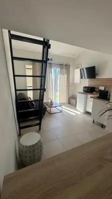 a living room with a kitchen and a table at Cosy House in Carpentras