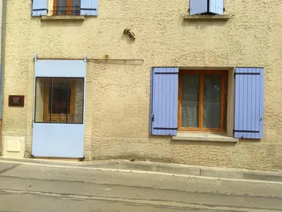 a building with blue shuttered windows and a white door at Les Studios proche du Mont Ventoux in Mazan