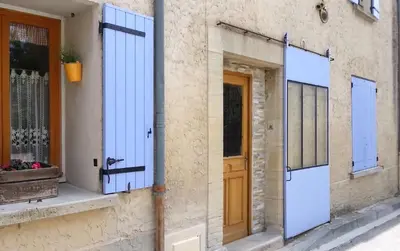 a facade of a house with blue doors at Les Studios proche du Mont Ventoux in Mazan