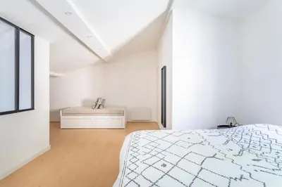 a white bedroom with a bed and a window at Charmant T3 proche centre ville avec parking in Aix-en-Provence
