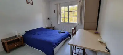 a small bedroom with a blue bed and a table at Chambre d'hôte BB proche d'Aix en Provence in Éguilles