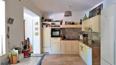 a kitchen with white cabinets and a tile floor at Chambre d'hôte BB proche d'Aix en Provence in Éguilles