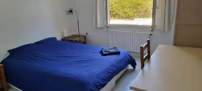 a blue bed in a room with a window at Chambre d'hôte BB proche d'Aix en Provence in Éguilles