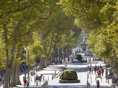 a park with trees and people walking around a fountain at Le Cardinale - Un Voyage en Provence - 2 chambres avec parking in Aix-en-Provence