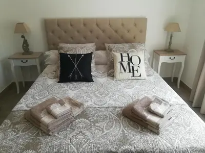 a bed with two pillows and towels on it at Le Mazet d'Olivia, escapade romantique en Provence in Châteauneuf-de-Gadagne