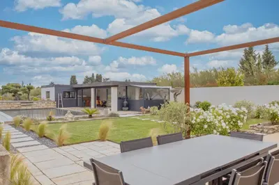 a home with a view of the backyard with a table and chairs at Le Mas des Oliviers in Châteaurenard