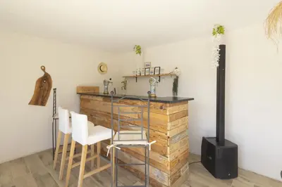a kitchen with a counter and chairs in a room at Le Mas des Oliviers in Châteaurenard