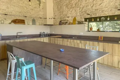 a kitchen with a large wooden table and chairs at Le Mas des Oliviers in Châteaurenard