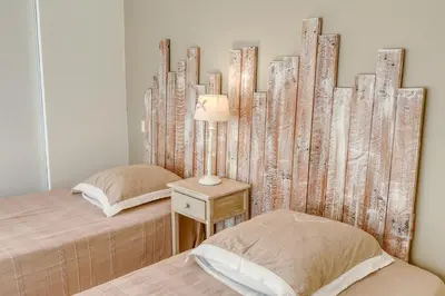 a bedroom with two beds and a table with a lamp at Gite neuf avec piscine Bio uv in Saint-Saturnin-les-Apt