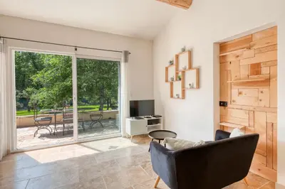 a living room with a couch and a sliding glass door at Gite neuf avec piscine Bio uv in Saint-Saturnin-les-Apt