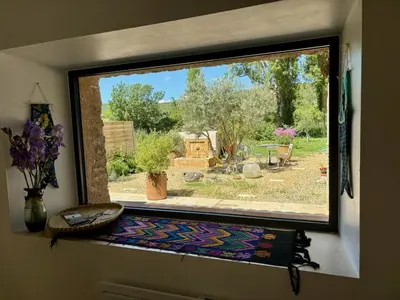 a window in a room with a view of a garden at Maison de charme avec piscine in Simiane-la-Rotonde