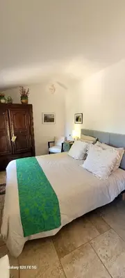 a bedroom with a large bed in a room at Maison de charme avec piscine in Simiane-la-Rotonde