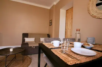 a living room with a table with dishes on it at Tiny Harmony - Logement confortable avec jardin et jacuzzi privés près d’Aix en Provence in Venelles