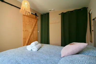a bedroom with a bed with two rolled up towels at Tiny Harmony - Logement confortable avec jardin et jacuzzi privés près d’Aix en Provence in Venelles