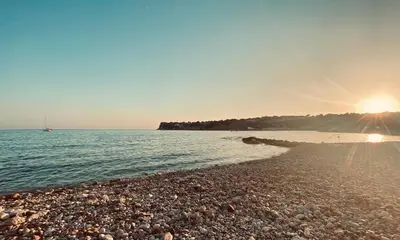 a rocky beach with the sun setting over the water at Tiny Harmony - Logement confortable avec jardin et jacuzzi privés près d’Aix en Provence in Venelles