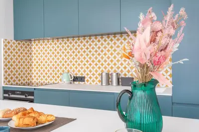 a green vase with flowers on a table in a kitchen at Magnifique appartement centre historique in Aix-en-Provence