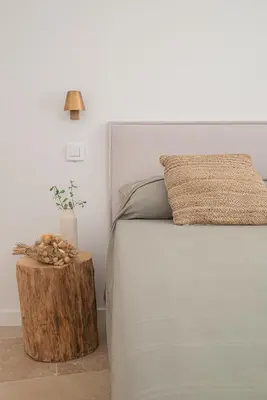 a bedroom with a bed with a wooden stump next to a table at VILLA VOGA- Luxury family holidays Aix-en-Provence in Éguilles