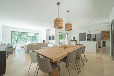 a kitchen and dining room with a wooden table and chairs at VILLA VOGA- Luxury family holidays Aix-en-Provence in Éguilles