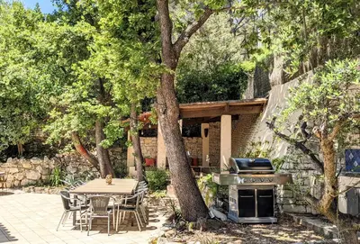 a patio with a table and a grill and trees at VILLA VOGA- Luxury family holidays Aix-en-Provence in Éguilles