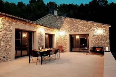 a patio with a table and chairs in front of a building at Villa Feijoa en Provence in Velleron