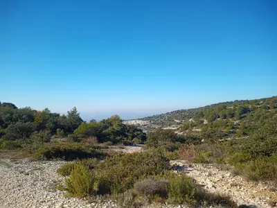 a view of a hill with the ocean in the background at Gite LE PETIT LUBERON COQUELICOT in Coustellet