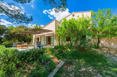 a small house with a patio and an umbrella at Villa sur 1 hectare 15 Personnes GORDES & ROUSSILLON in Croagnes