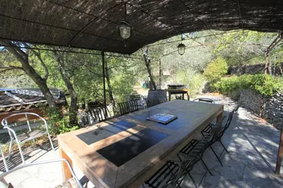 a wooden table and chairs on a patio at Charm in Provence in Saumane-de-Vaucluse