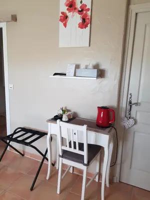 a table with a tea kettle and a chair in a room at Mas Clement - Chambre et table d'hôtes in LʼIsle-sur-la-Sorgue