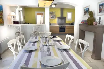 a dining room with a table and chairs and a kitchen at Ma villa en Provence villa de standing et piscine Domaine de Pont-Royal in Mallemort