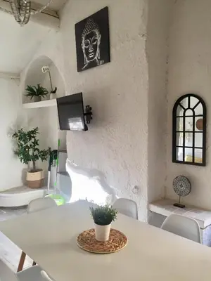 a room with a table and chairs and a tv at Appartement Emil centre ville in Carpentras