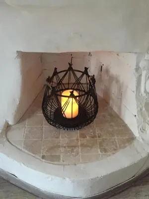 a candle in a basket hanging from a wall at Appartement Emil centre ville in Carpentras