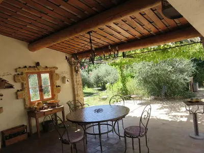 a patio with a table and chairs under a pergola at Appartement dans Mas Provencal in Grans