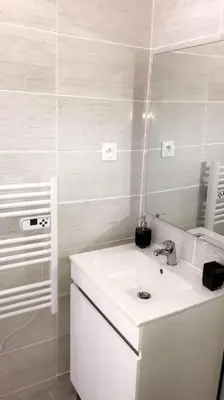 a white bathroom with a sink and a mirror at Studios moderne et spacieux in Morières-lès-Avignon