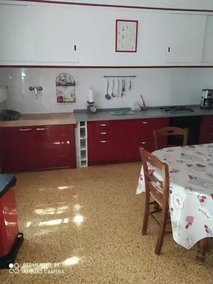 a kitchen with red cabinets and a table in it at La maison de Nazig in Pertuis