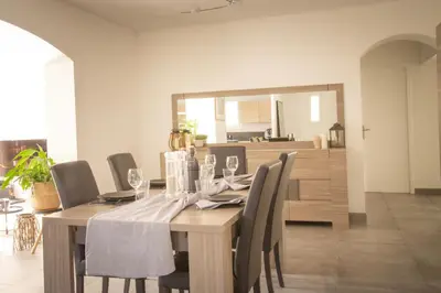 a dining room with a wooden table and chairs at Maison Loutina, Villa 5 min à pied du centre in LʼIsle-sur-la-Sorgue