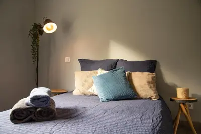a bed with a blanket and pillows on it at Maison Loutina, Villa 5 min à pied du centre in LʼIsle-sur-la-Sorgue