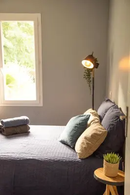 a bedroom with a bed with pillows and a window at Maison Loutina, Villa 5 min à pied du centre in LʼIsle-sur-la-Sorgue
