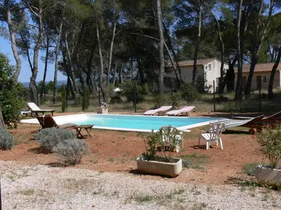 a swimming pool with a group of chairs around it at La Coudoulière in Saint-Rémy-de-Provence