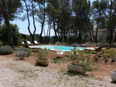 a swimming pool with a bunch of chairs and a table at La Coudoulière in Saint-Rémy-de-Provence