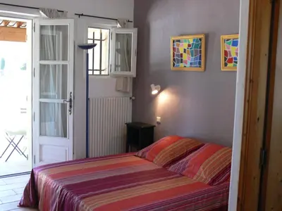 a bedroom with a bed and a door to a patio at La Coudoulière in Saint-Rémy-de-Provence