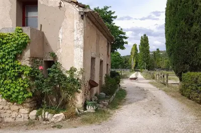 an empty road next to a building with vines at Chambre d'Hotes Manon - Domaine Les Peupliers - in Lagnes