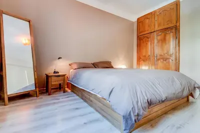 a bedroom with a large bed and a wooden cabinet at Le Blondel in Aix-en-Provence