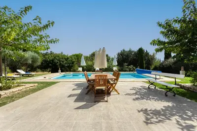 a patio with two chairs and a table next to a pool at Le mas sous les étoiles in Joucas