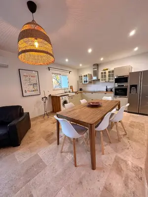 a kitchen and dining room with a wooden table and chairs at L'appart des Anges in Althen-des-Paluds