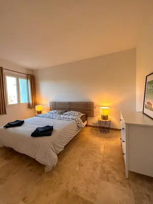 a bedroom with a bed with two lamps on it at L'appart des Anges in Althen-des-Paluds