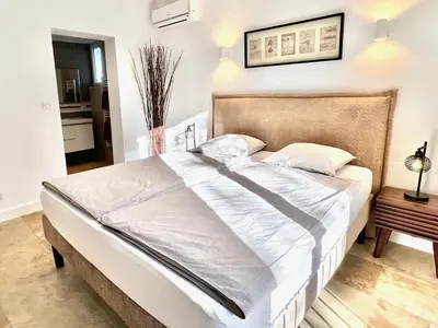 a bedroom with a large bed with white sheets at provence living in Roussillon